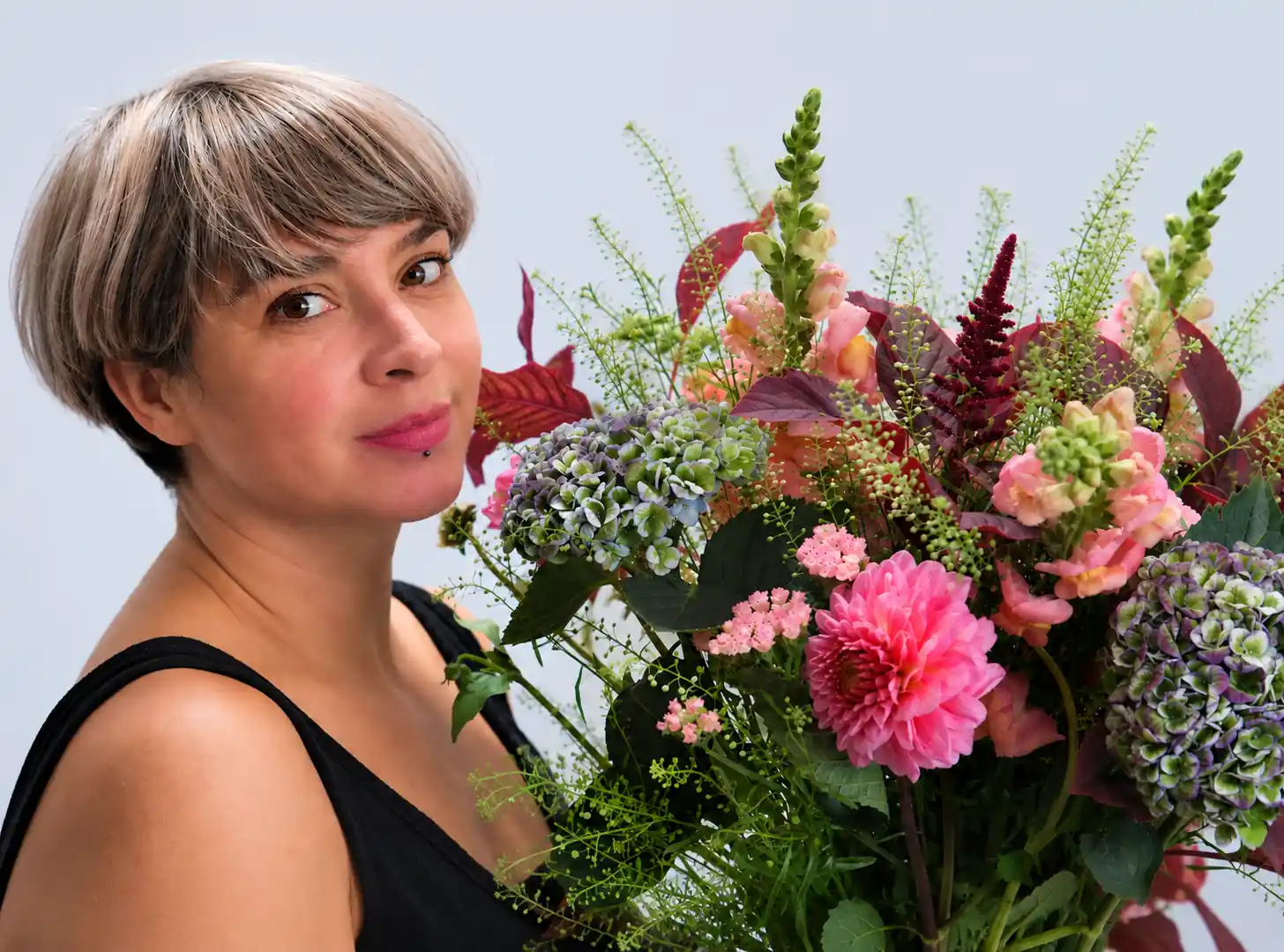 Pénélope, fleuriste à Strasbourg, avec un bouquet de fleurs.